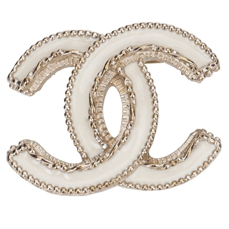 An authentic white enamel and gold-tone bead chain Chanel interlocking CC logo broach, demonstrating a key status symbol in Chanel classic elements.
