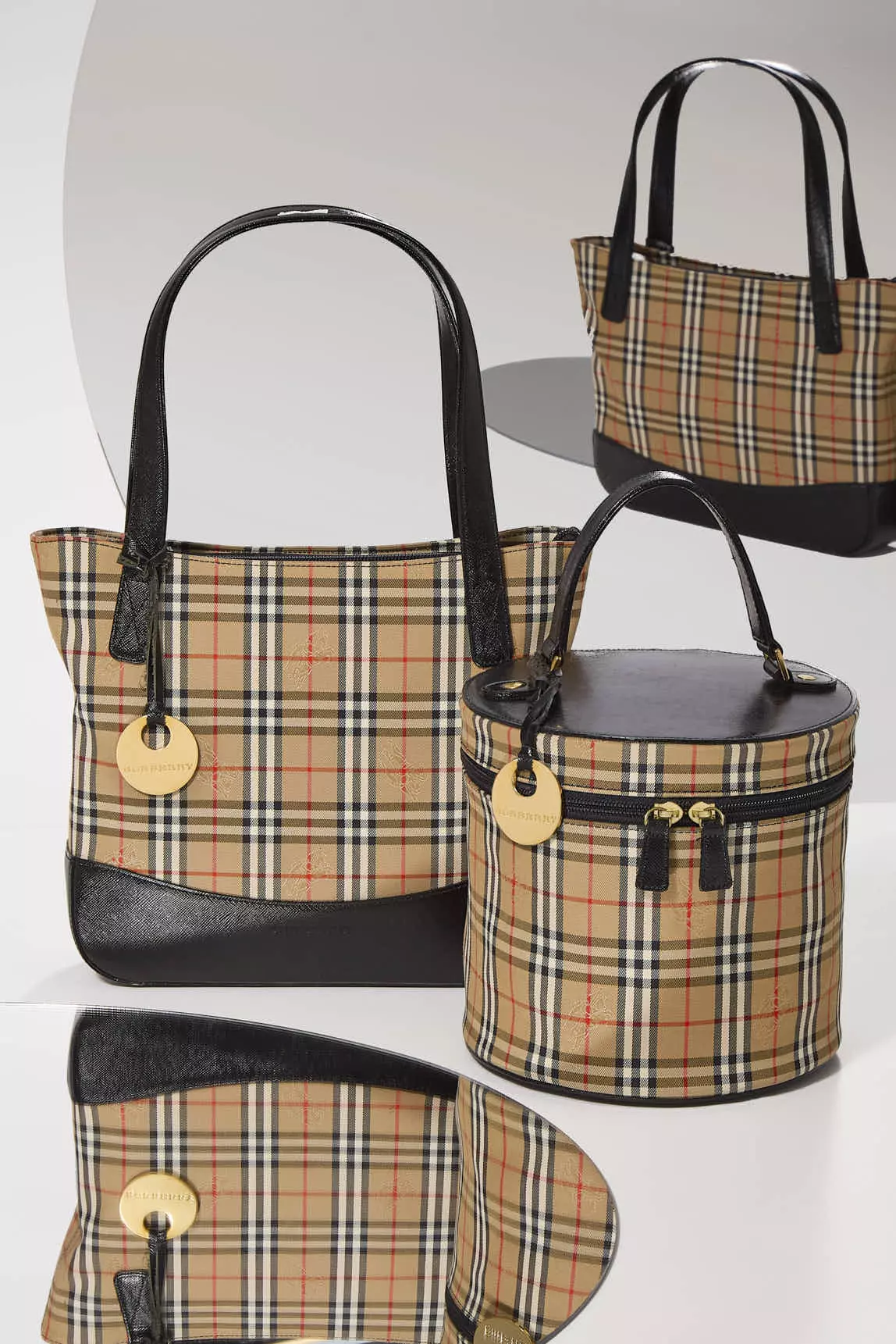 Shop by Brand: Two Burberry bags reflecting in mirrors