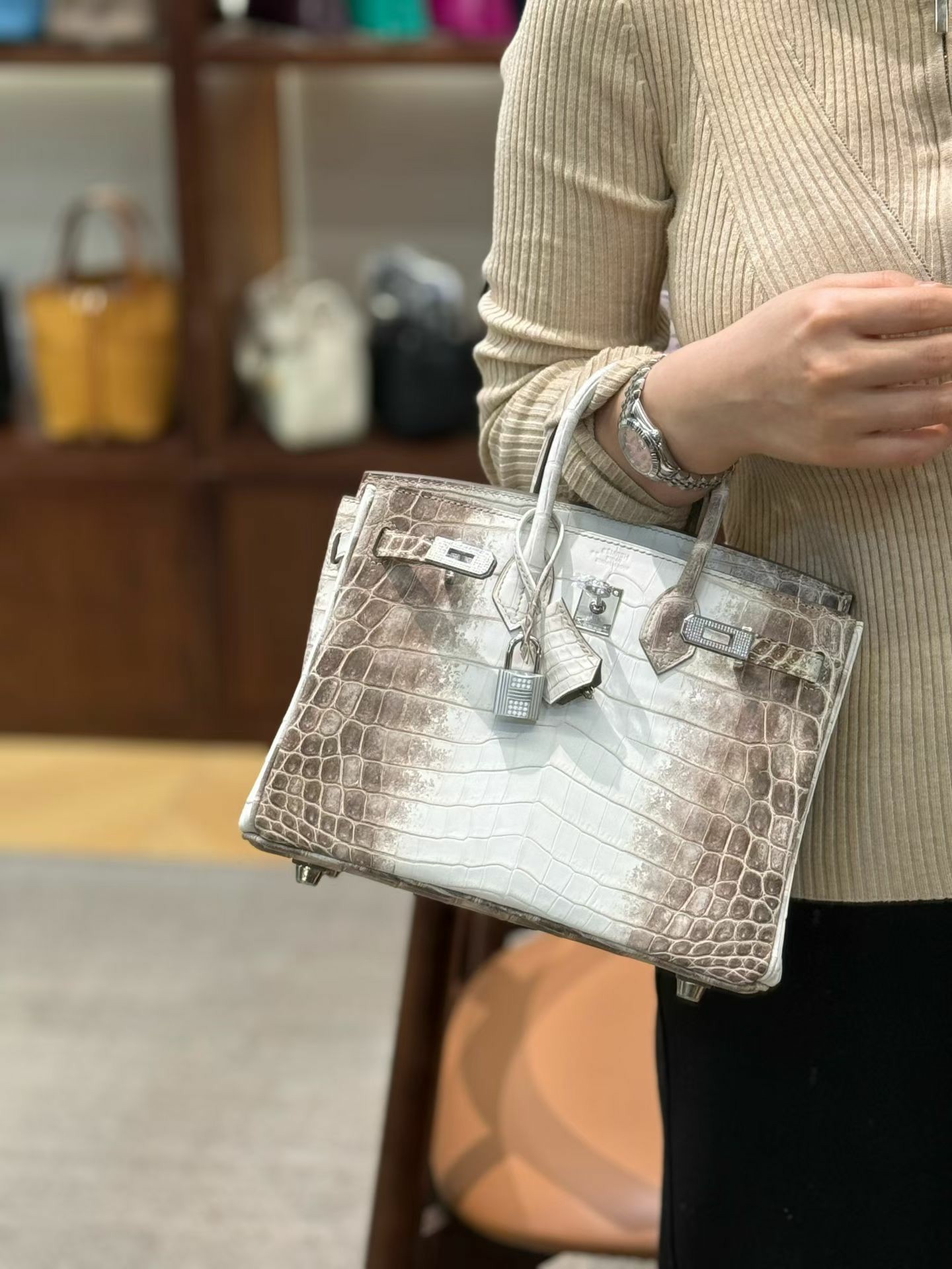 A collectsor wears a customized Himalayan Birkin 25 with diamond-grade hardware on her arm
