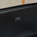Carrying the black replica Hermes Bolide 31 Bag by its top handle.