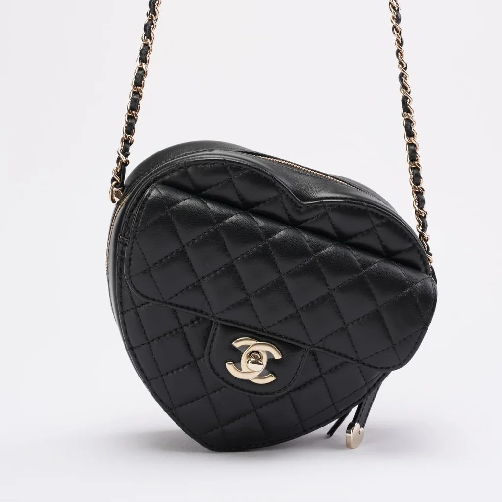 Black quilted handbag with chain strap on a white background