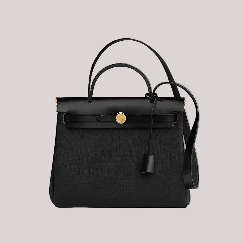 Black handbag with a gold clasp on a beige background

